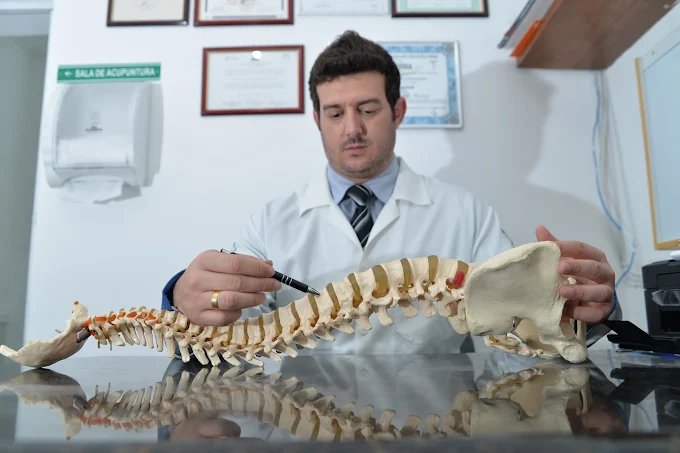 Dr. Denner Fonseca explicando a anatomia da coluna vertebral com um modelo anatômico